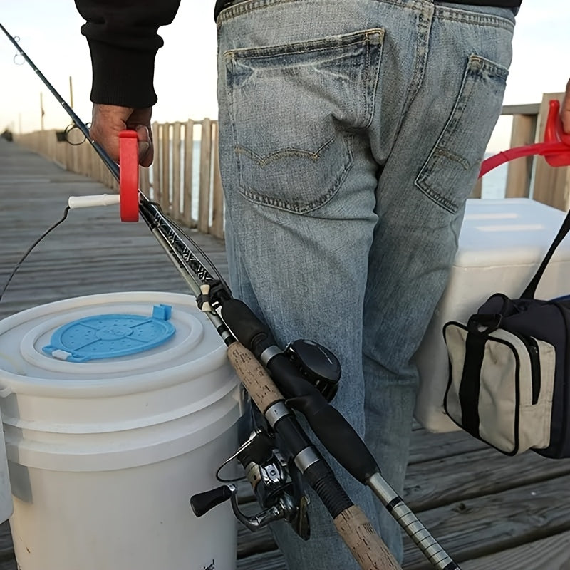 A person using a red HandCarry Handle to effortlessly carry fishing gear, including a white cooler bucket and fishing rods, while walking on a wooden pier, demonstrating its utility for outdoor activities and transporting bulky items.