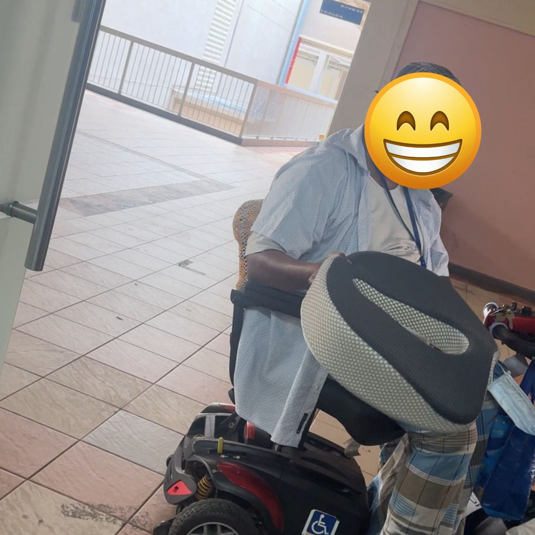 Elderly Singapore senior holding JC Health anatomical donut cushion for back pain relief outside Waterloo Street showroom.