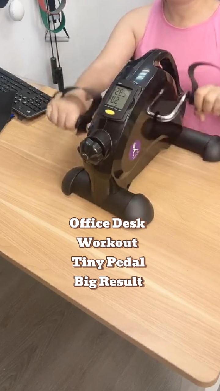 Office worker using JC Health mini desk bike for arm and leg exercise at workplace to combat office syndrome and stay active during work hours