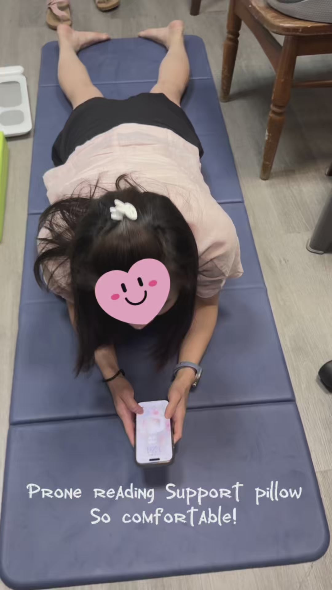 Real customer review demonstrating the JC Health 4-in-1 lounge wedge for prone phone reading. Video shows a young girl comfortably browsing her phone on her stomach with zero chest pressure, highlighting the ergonomic breast support and perfect viewing height of the memory foam cushion